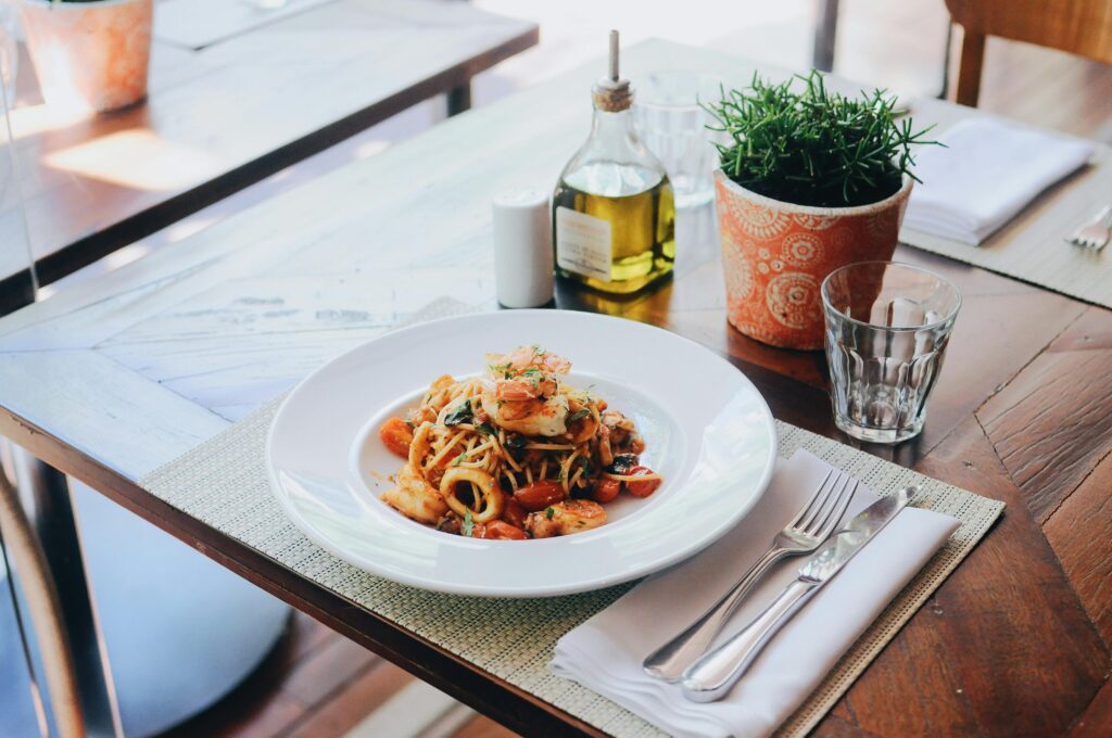 pexels photo 2433978 2433978 1 A delectable seafood pasta dish with olive oil and fresh herbs on a restaurant table setting.